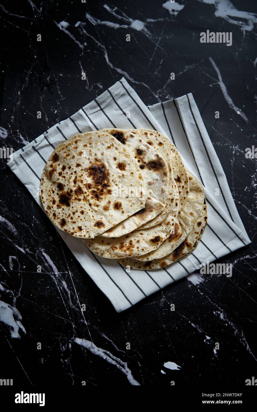 Gebratenes Pita-Brot in der Pfanne auf dunklem Hintergrund. Draufsicht Stockfoto