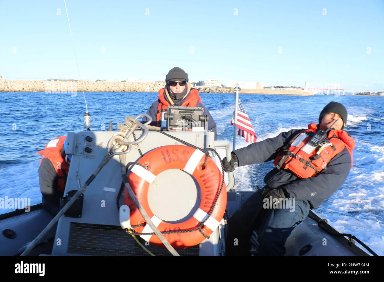 SAGAMI WAN, Japan (24. Januar 2023) Boatswain’s Mate Seaman Joshua Nesbit aus Charlotte, North Carolina, übernimmt das starre aufblasbare Boot (RIB) als Coxswain, und ENS Jordan McDaniel aus Valparaiso, Indiana, leitet die RIB-Crew als Bootsoffizier, während Passagiere von Howard auf die Insel Jogashima gebracht werden. Howard ist dem Befehlshaber, der Task Force (CTF) 71/Destroyer Squadron (DESRON) 15, der größten nach vorn eingesetzten DESRON der Marine und der Hauptstreitkräfte der US-7.-Flotte zugewiesen. Stockfoto