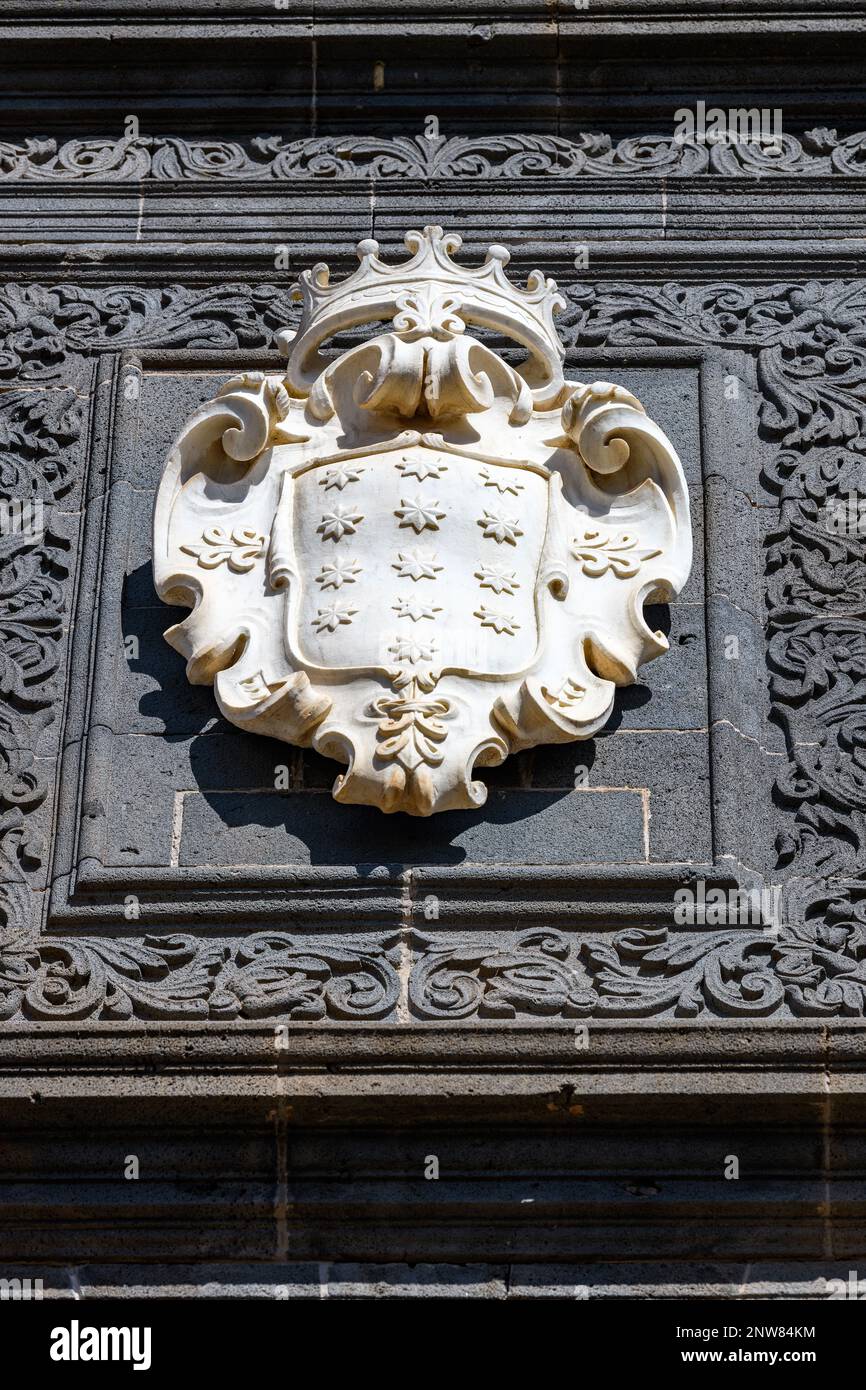 Das Wappen des Salazar aus weißem Carrara-Marmor steht in starkem Kontrast zur verzierten dunkelblauen Steinfassade des Salazar-Palastes in La Laguna auf Teneriffa Stockfoto