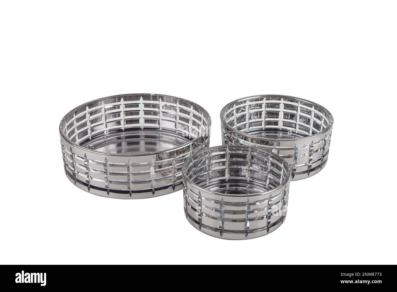 Drei Kerzenhalter aus Glas mit Kerzen auf weißem Hintergrund. Set mit 3 Kerzenhaltern aus Kristall. Stockfoto