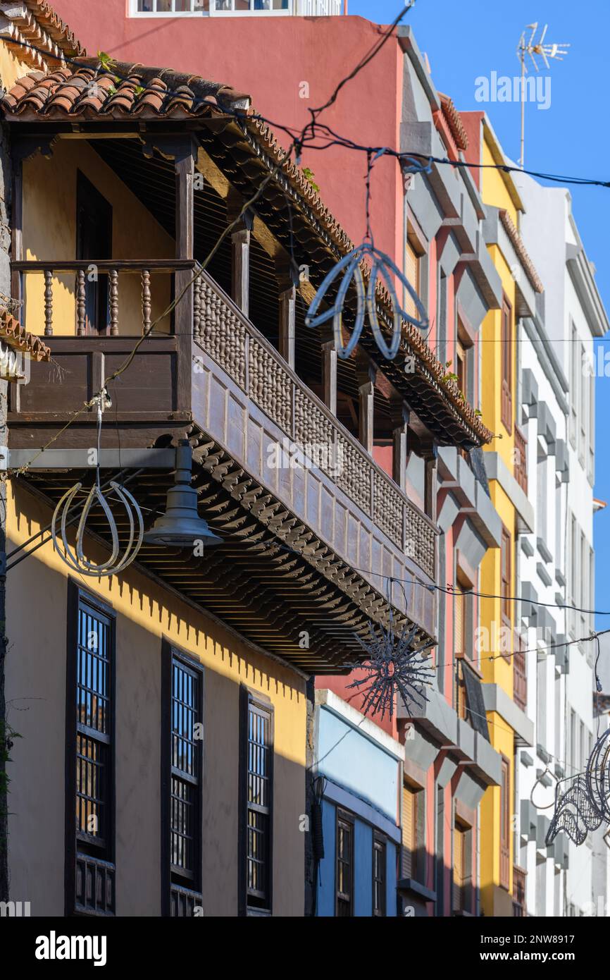 Ein archetypischer kanarischer Holzbalkon befindet sich im zweiten Stock eines lebhaften gelben Gebäudes in der Calle Herradores, San Cristobal de la Laguna Stockfoto