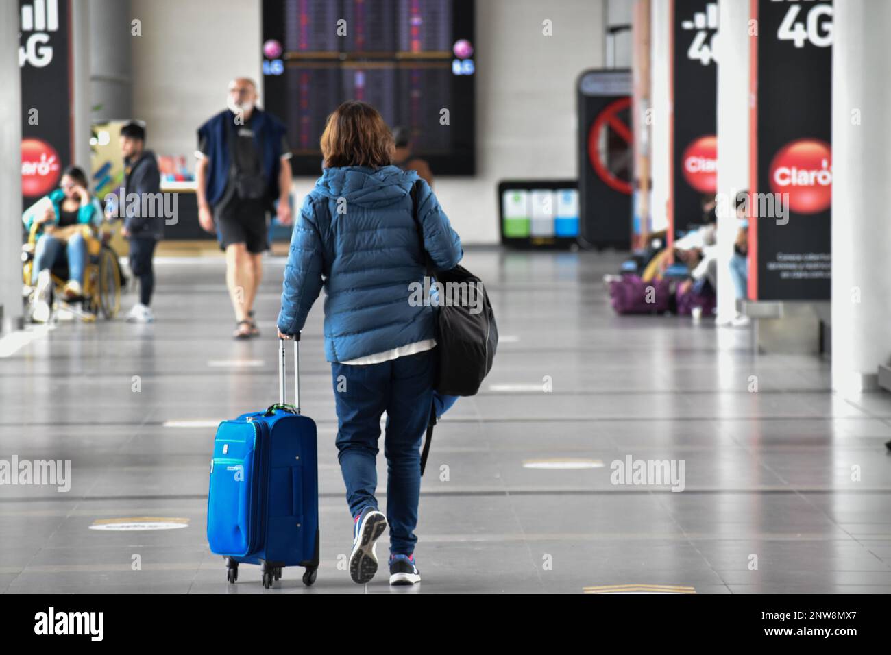 Bogota, Kolumbien, Dienstag, 28. Februar 2023. Eine Frau geht mit ihrem Gepäck, nachdem die Billigfluggesellschaft Viva Air ihren Betrieb am El Dorado International Airport in Bogota, Kolumbien, am Dienstag, den 28. Februar 2023, eingestellt hat. Die Fluggesellschaft wartet auf einen Integrationsprozess mit einer Gruppe von Fluggesellschaften, der von den kolumbianischen Luftfahrtbehörden genehmigt werden muss. Foto von: Cristian Bayona/Long Visual Press Stockfoto