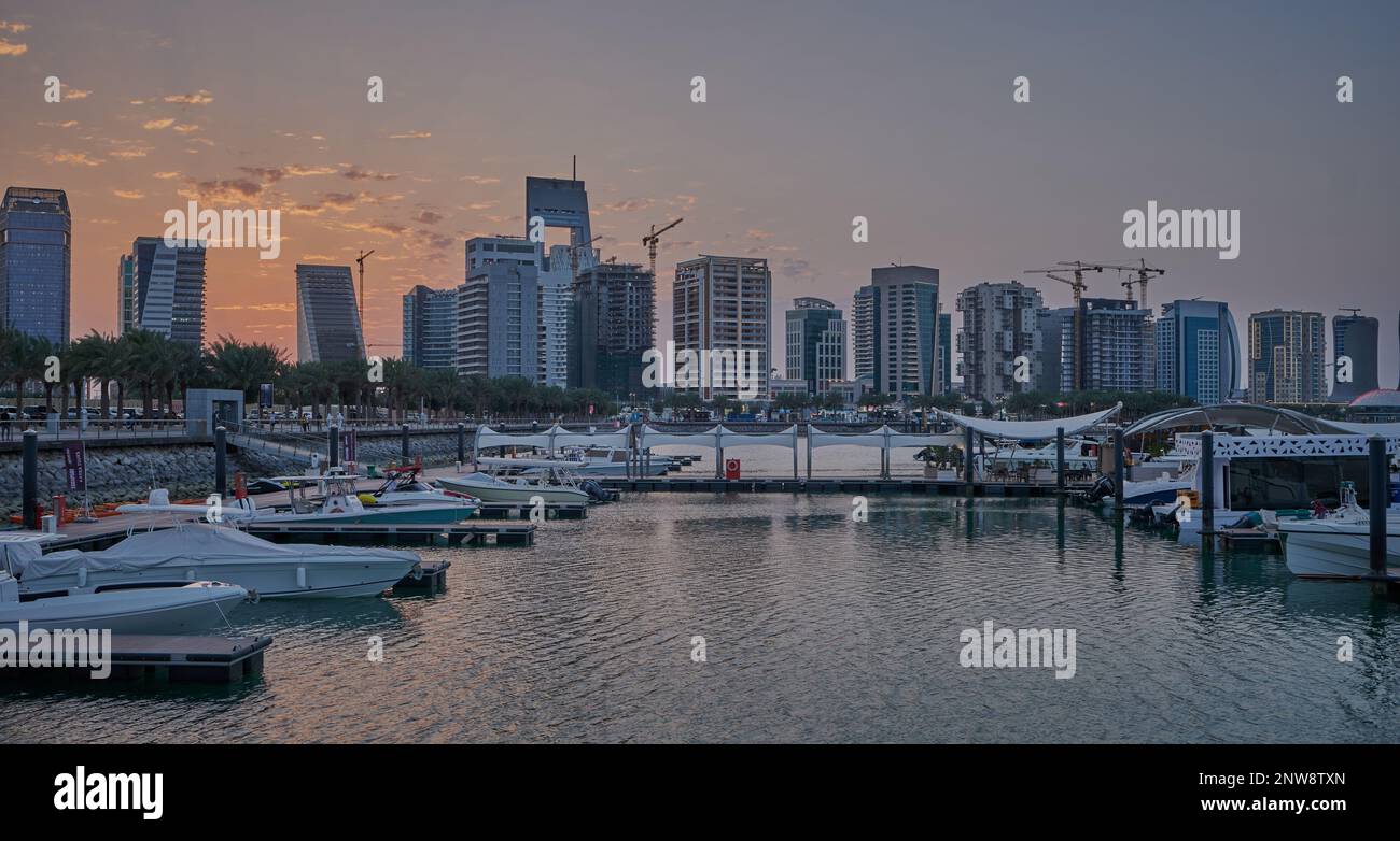 Lusail Marina in Lusail City, Katar Sonnenuntergang Aussicht mit Yachten und Booten mit Katar Flagge, Lusail Skyline und Wolken am Himmel im Hintergrund Stockfoto