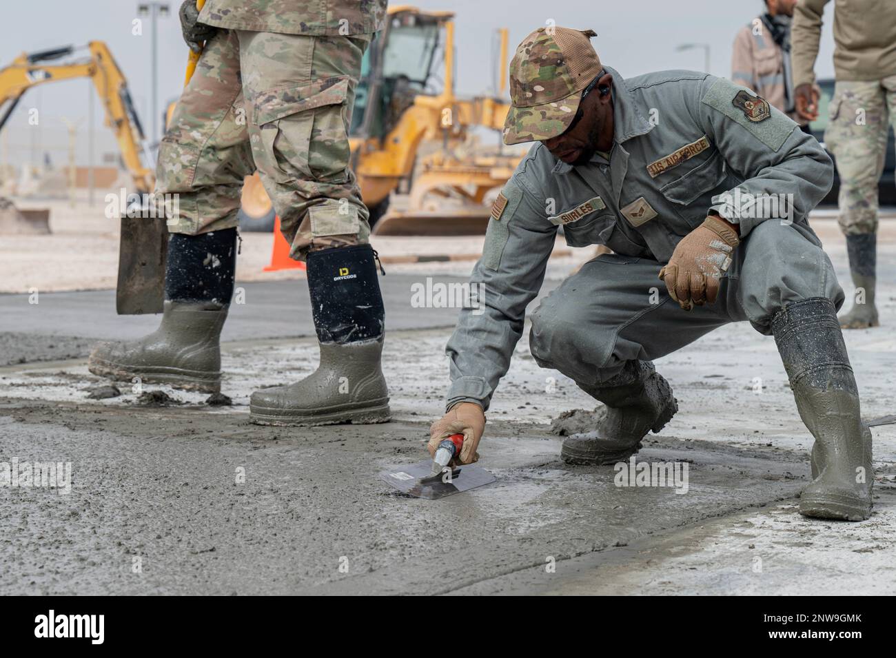 Senior Airman Jamond Surles, 379. Expeditionary Civil Engineer Squadron Bordstein und Baumaschinen Journeyman, verwendet eine Stahlkelle mit abgerundeten Kanten, um eine glatte Oberfläche während eines Betonerweiterungsprojekts auf dem Gelände der Expeditionary Logistics Readiness Squadron 379. auf dem Luftwaffenstützpunkt Al Udeid, Katar, 12. Januar 2023 zu gewährleisten. Der 379. ECES-Flugdienst für Gehwege und Bauarbeiten führt Basisverbesserungsprojekte durch, um die Infrastruktur zu erweitern und zu verbessern und die Basiseffizienz zu erhöhen. Stockfoto