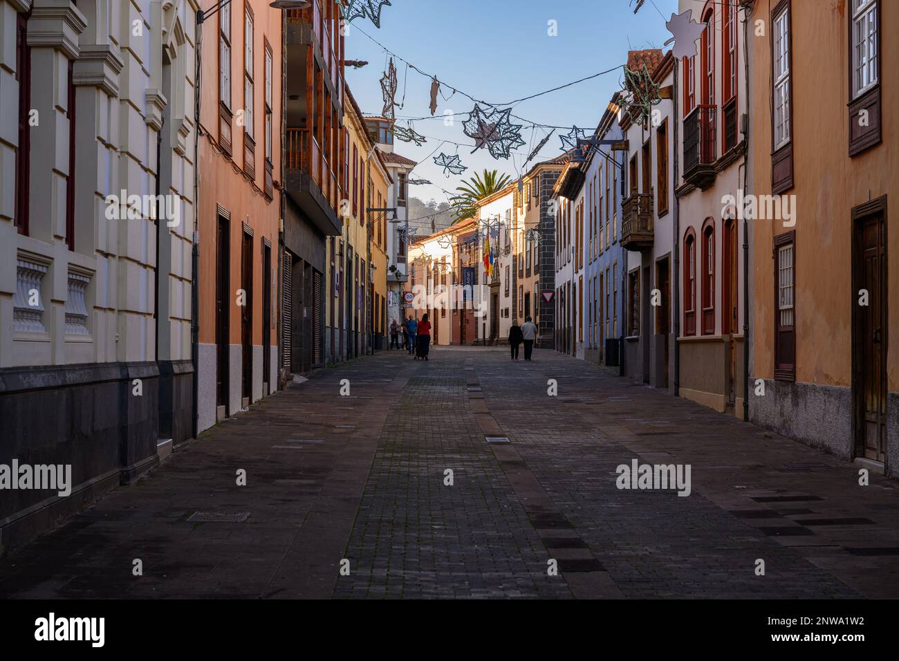 Siesta-Zeit in La Laguna Calle San Agustin. Die Wintersonne am späten Nachmittag fängt die Weihnachtsdekoration auf der anderen Seite der ruhigen Straße ein Stockfoto