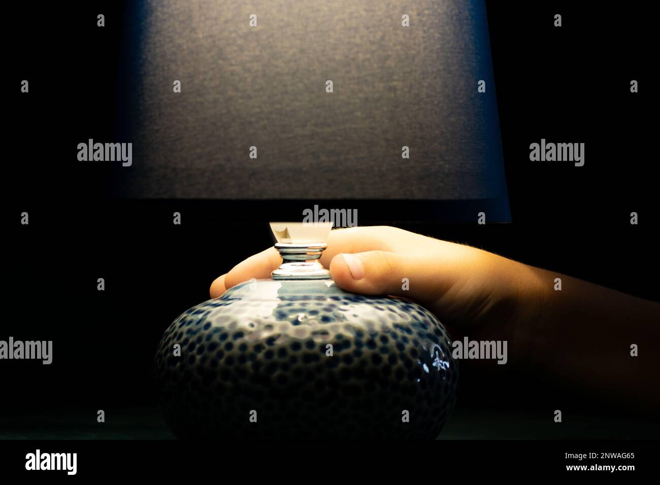 Nachttischlampe im Lieferumfang enthalten, die im Dunkeln leuchtet und von einem Kind in der Hand gehalten wird, Lampe im Retro-Stil Stockfoto