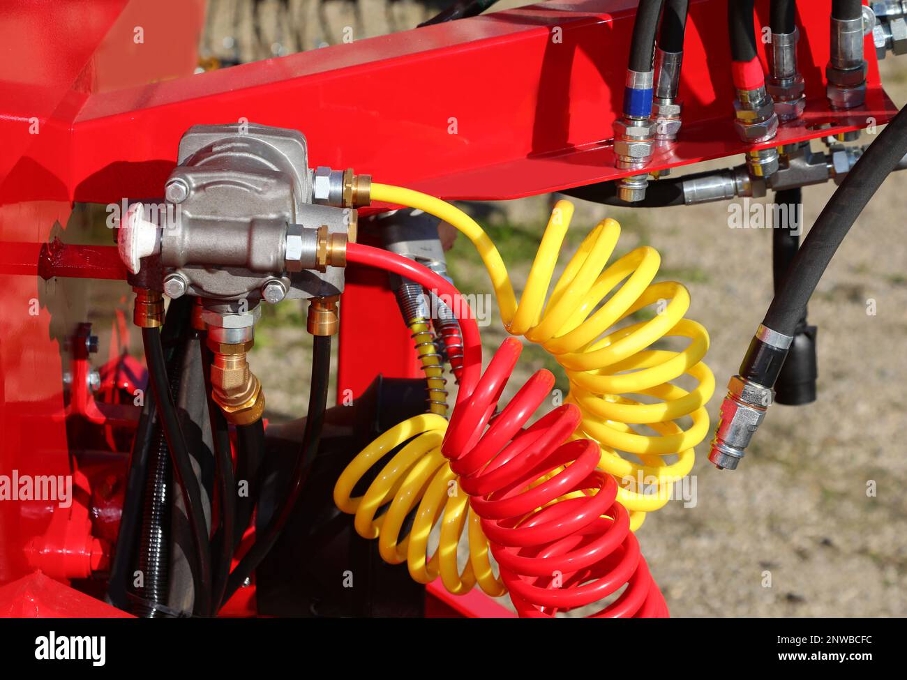 Rote und gelbe Druckluftröhren und das oleodynamische System einer Industriemaschine im Werk Stockfoto