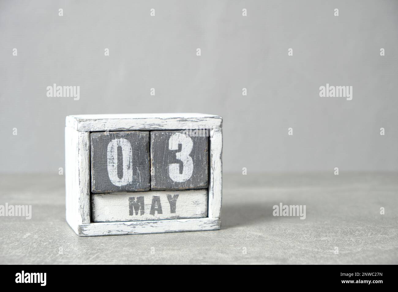 Mai 3, auf Kalender aus grauem und weißem Holz mit grauem Hintergrund Stockfoto