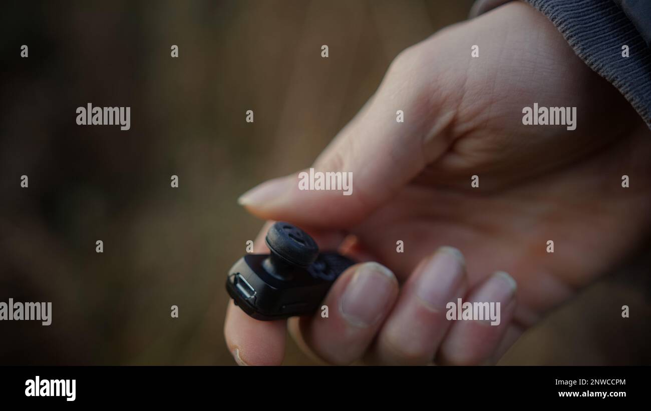 Nahaufnahme von Bluetooth-Kopfhörern in der Hand Stockfoto