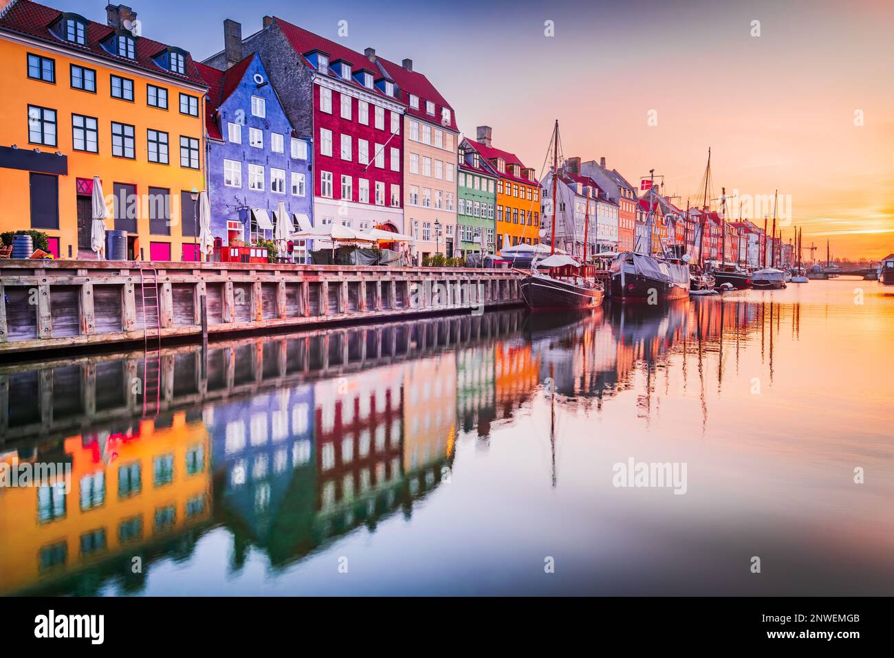 Kopenhagen, Dänemark. Charme des Nyhavn-Kanals, ikonischer Ort, farbenfroher Sonnenaufgang und atemberaubende Wasserreflexionen. Stockfoto
