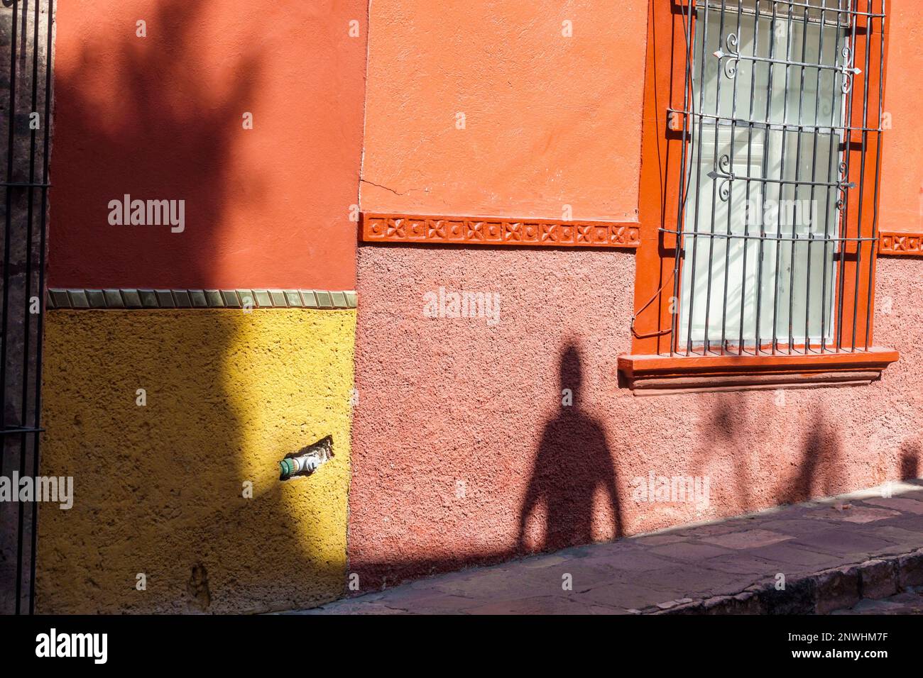 San Miguel de Allende Guanajuato Mexico, historisches Zentrum des historischen Stadtzentrums, menschliche Schattensilhouette, farbenfrohe orangefarbene Mauer, Gebäude, Stadt Stockfoto