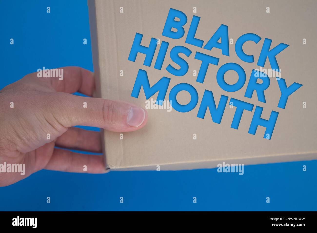 Schwarzes Monatswort mit Pappschachtel. Brauner gefalteter Karton. Stockfoto