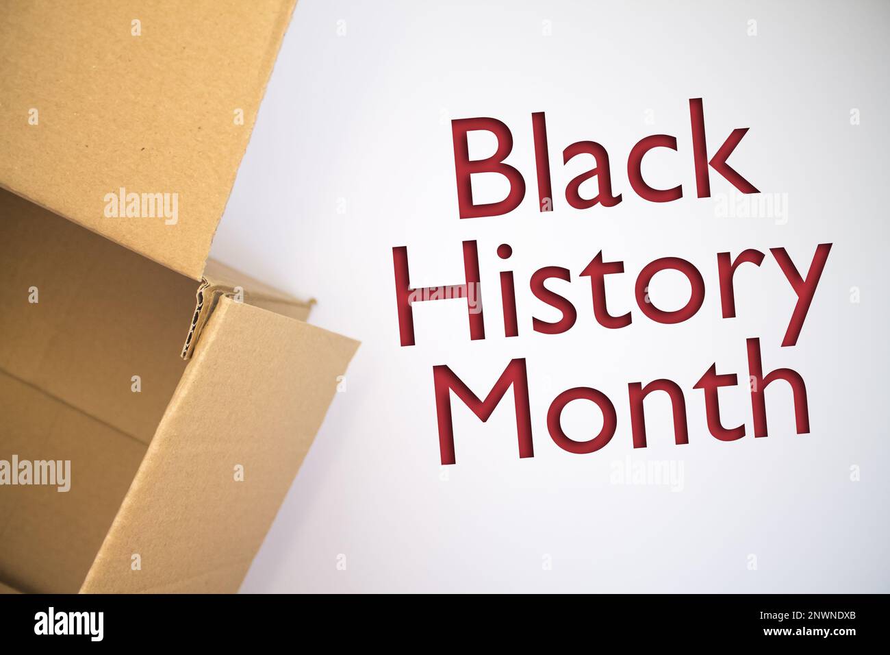 Schwarzes Monatswort mit Pappschachtel. Brauner gefalteter Karton. Stockfoto