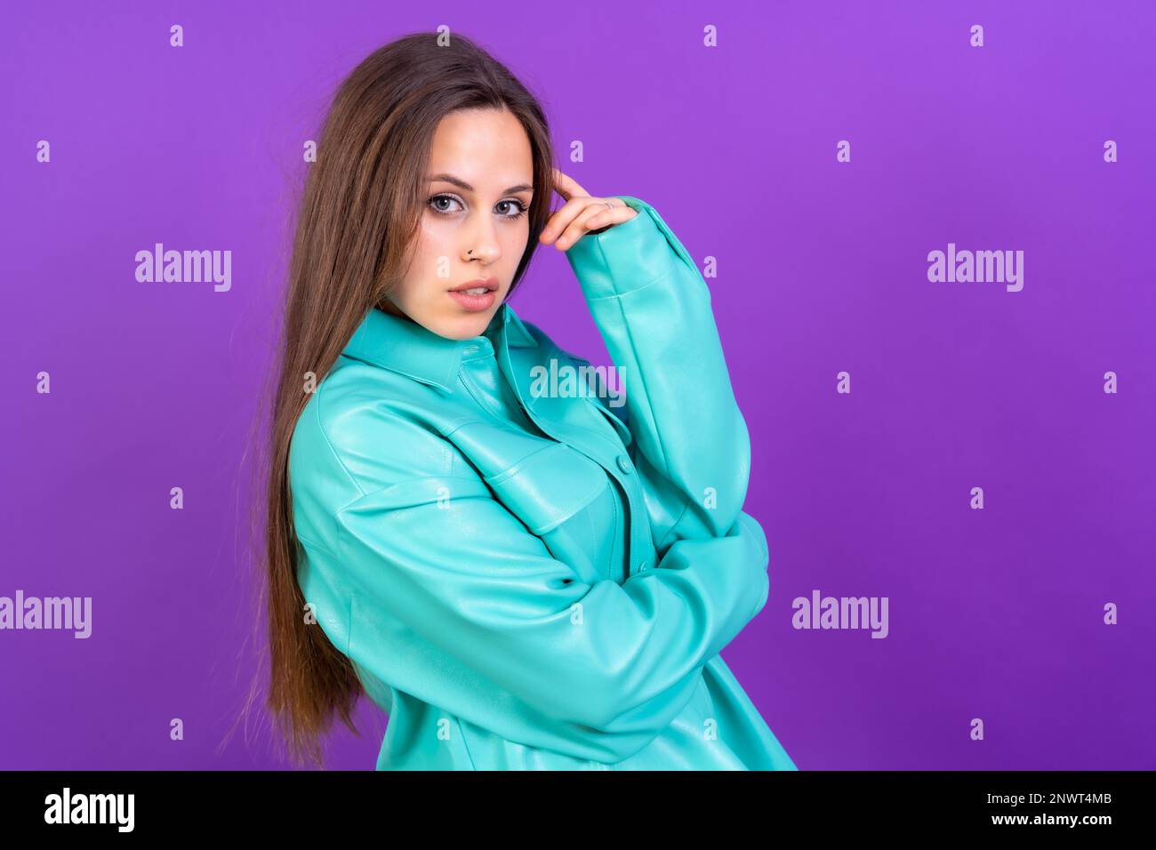 Nahaufnahme einer jungen Weißen in blauem Trenchcoat isoliert auf lila Studiohintergrund Stockfoto