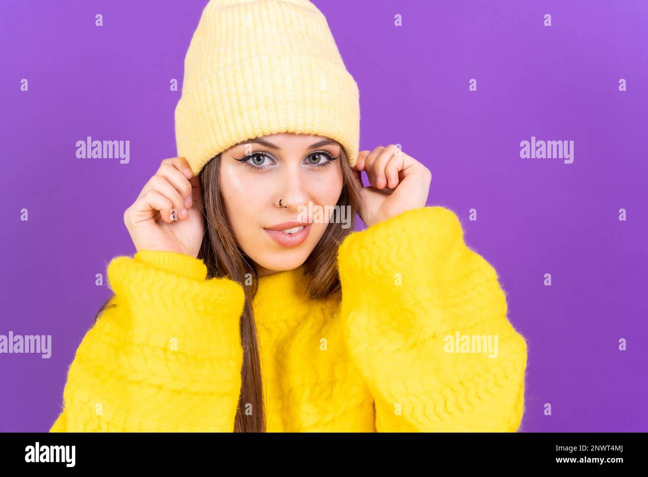 Nahaufnahme eines jungen Weißen in gelbem Pullover isoliert auf gelbem Hintergrund mit Wollmütze Stockfoto