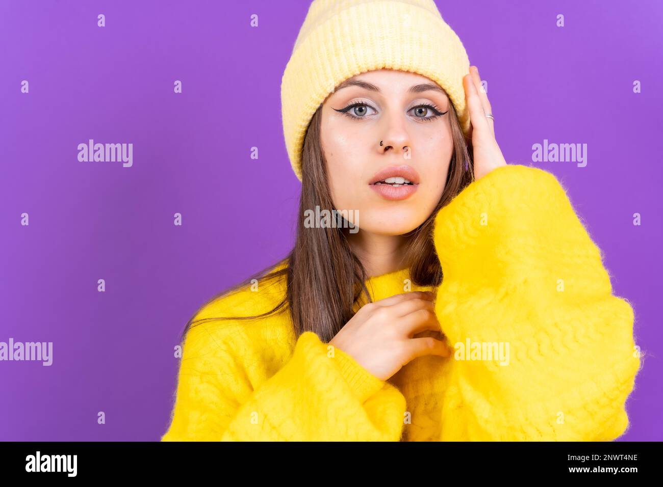 Nahaufnahme eines jungen Weißen in einem gelben Wollpullover isoliert auf gelbem Hintergrund, der in die Kamera schaut Stockfoto
