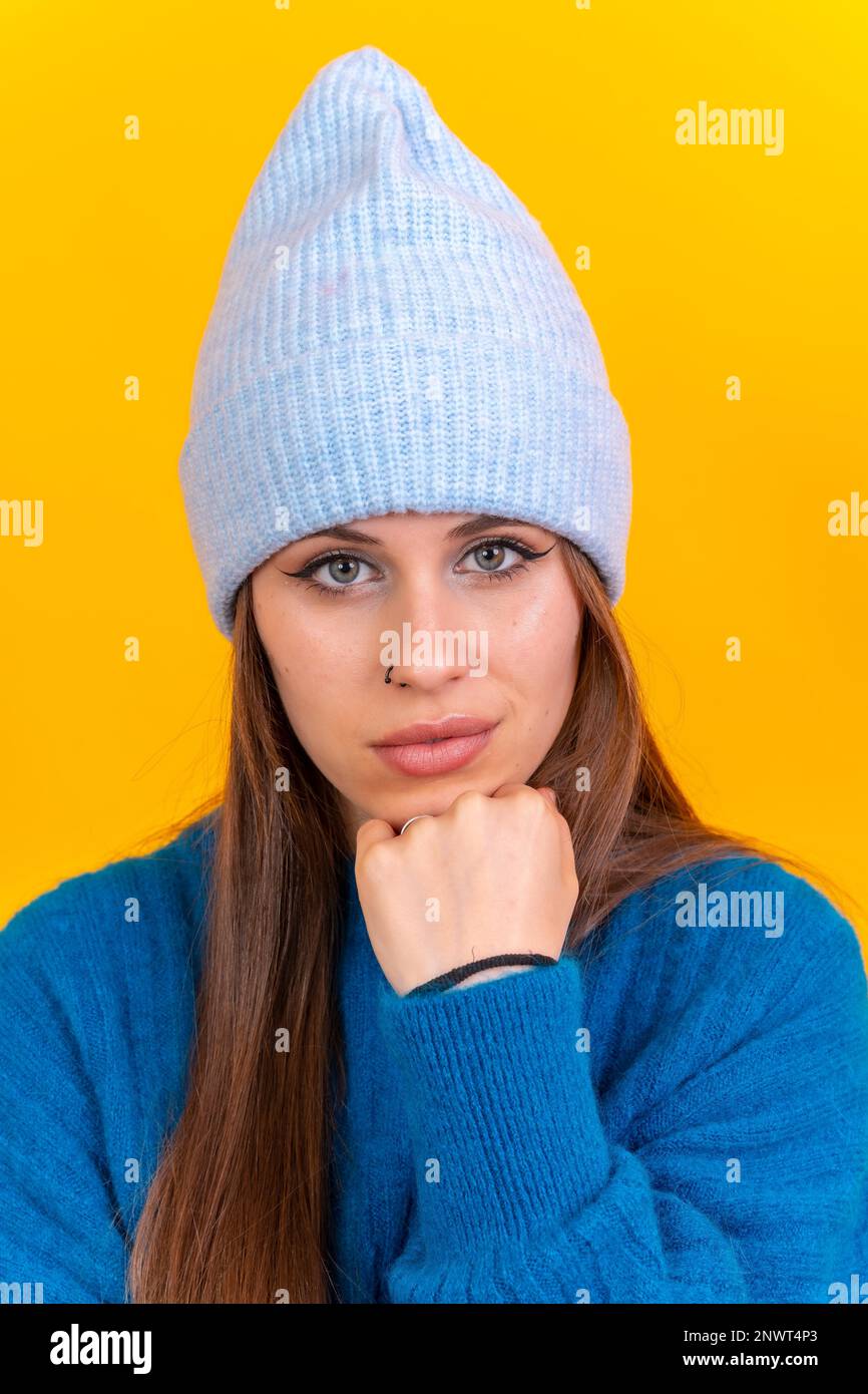 Nahaufnahme eines Porträts einer jungen Kaukasierin, die einen blauen Wollpullover trägt, isoliert im Hintergrund, in die Kamera schaut Stockfoto