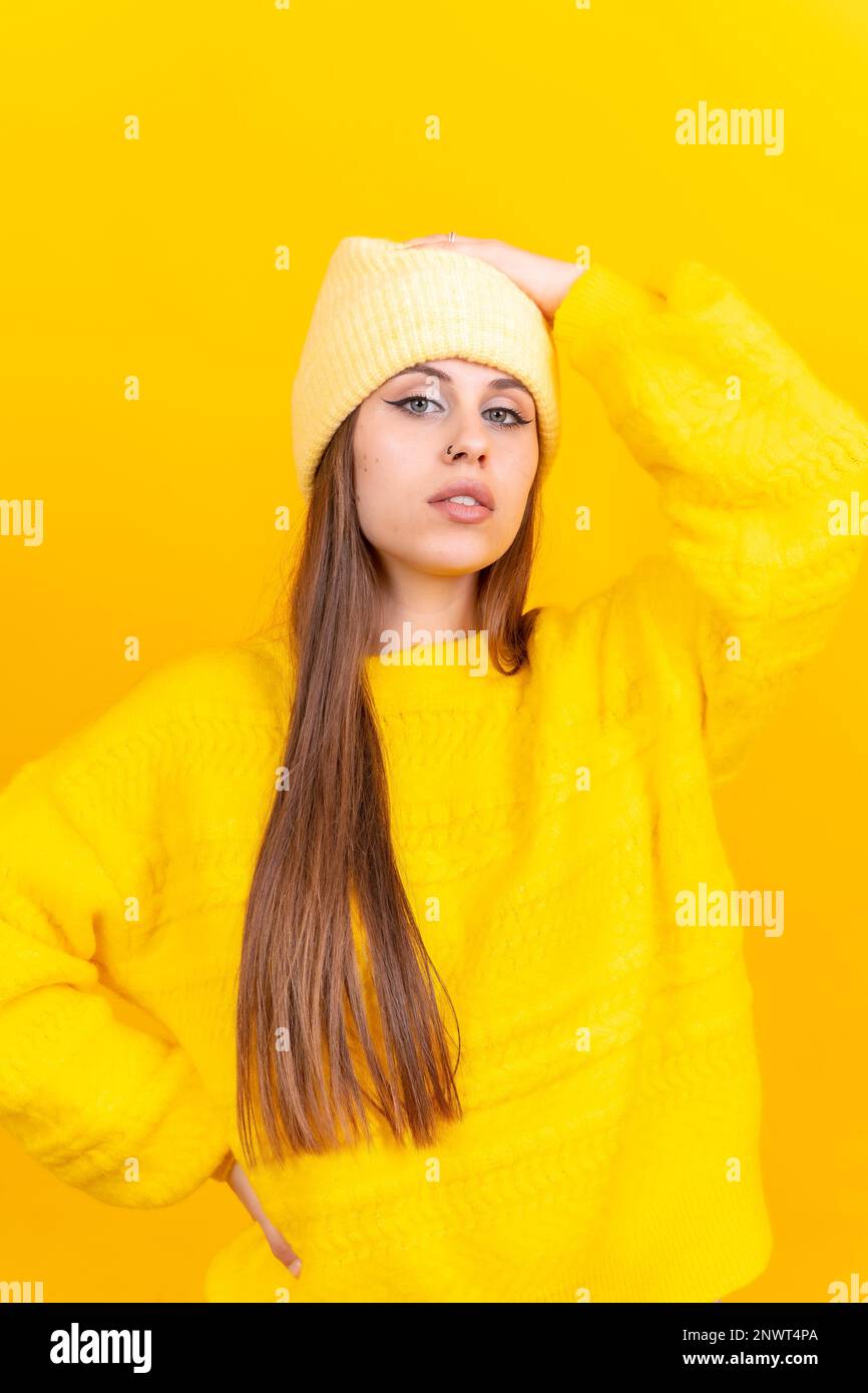 Nahaufnahme einer jungen Kaukasierin in Wollpullover isoliert auf gelbem Hintergrund im Studio Stockfoto