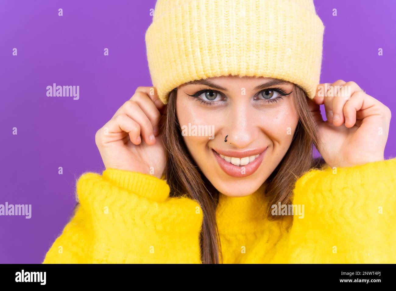 Nahaufnahme eines jungen Weißen in gelbem Pullover isoliert auf gelbem Hintergrund mit Wollmütze Stockfoto