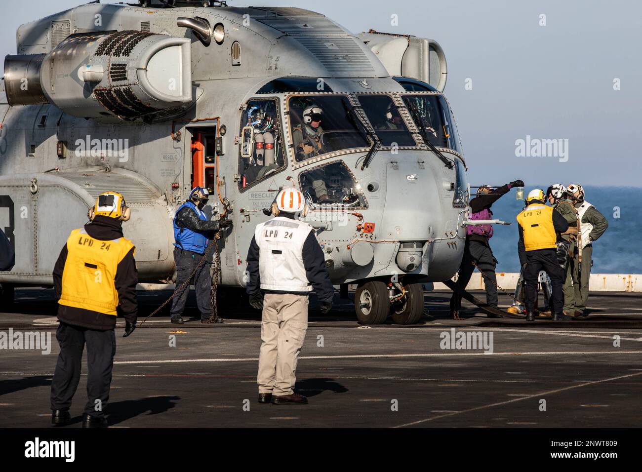 Matrosen, die dem Amphibienschiff USS Arlington (LPD 24) der San Antonio-Klasse zugewiesen sind, tanken einen Sikorsky CH-53K King Hallion Helikopter an Bord von Arlington am 7. Februar 2023 auf. Der King Hallion ist ein schwerer Frachthubschrauber, der als nächste Weiterentwicklung der seit 1966 in Betrieb befindlichen Hubschrauber der CH-53-Serie Seetests unterzogen wird. Stockfoto