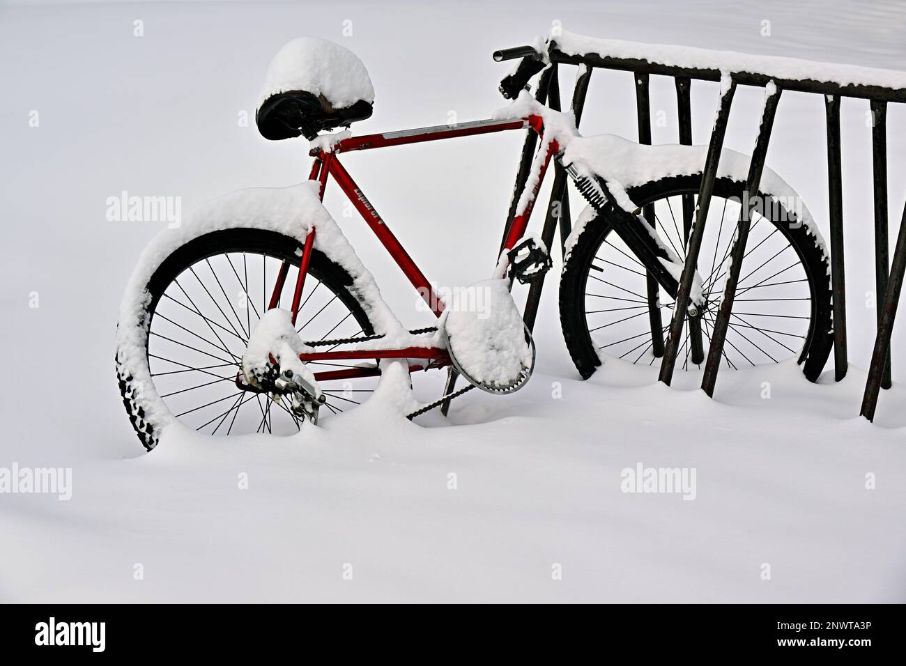 Ein Mountainbike, das in einem Lagerbereich gelagert wird, der mit dem frischen Winterschnee im ländlichen Alberta, Kanada, bedeckt ist. Stockfoto