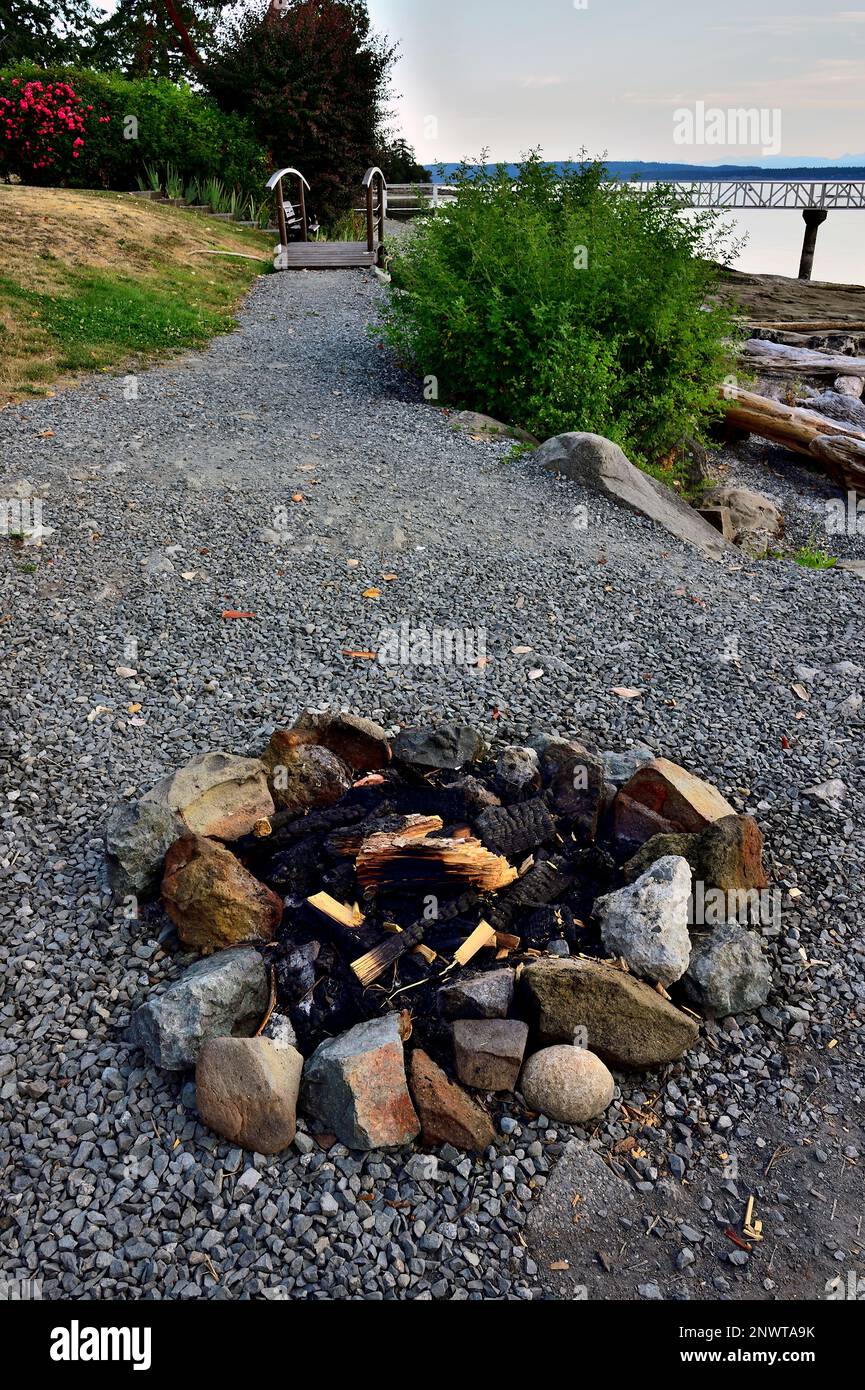 Ein vertikales Bild eines Steinkreises, der für ein Lagerfeuer an einem felsigen Strand auf Vancouver Island verwendet wurde Stockfoto
