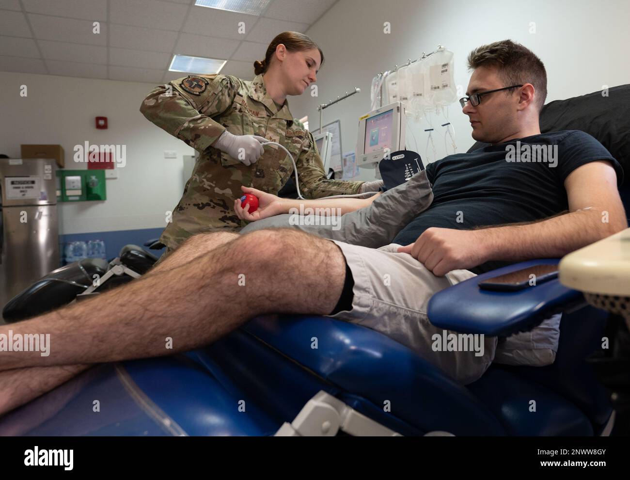 Staff Sgt. Season Bachman, 379. Labortechniker der Expeditionary Medical Support Squadron, legt eine Blutdruckmanschette an Airman 1. Class Mason Amadio, 8. Expeditionary Airlift Squadron Waffensysteme Controller, 24. Januar 2023, auf der Al Udeid Air Base, Katar. Die Apherese ist eine Technologie, die rote Blutkörperchen, weiße Blutkörperchen, Blutplättchen und Plasma durch Zentrifugation trennt. Mit sterilen Geräten leitet der Techniker die Thrombozyten in einen Entnahmebeutel, während der Rest des Blutes an den Spender zurückgegeben oder entsorgt wird. Stockfoto