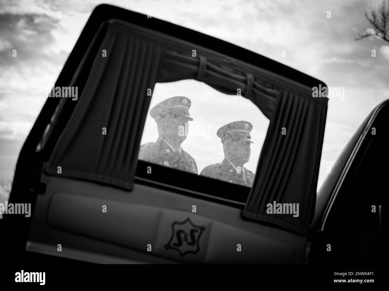 Mitglieder der Iowa Army National Guard Begräbnismannschaft, eingerahmt durch das Fenster eines Leichenwagens, stehen während einer Gedenkfeier für Staff Sgt. David Mosinski am Saint Mary's Cemetery in Wilton, Iowa, am 16. Januar 2023 zur Verfügung. Mosinski starb bei einem Autounfall im Januar 8. Er war bei der Iowa Army National Guard als Mechaniker für Radfahrzeuge bei der 3654. Supply Maintenance Company tätig und hatte kürzlich 20 Jahre in seinem Bundesstaat und Land gearbeitet. Stockfoto