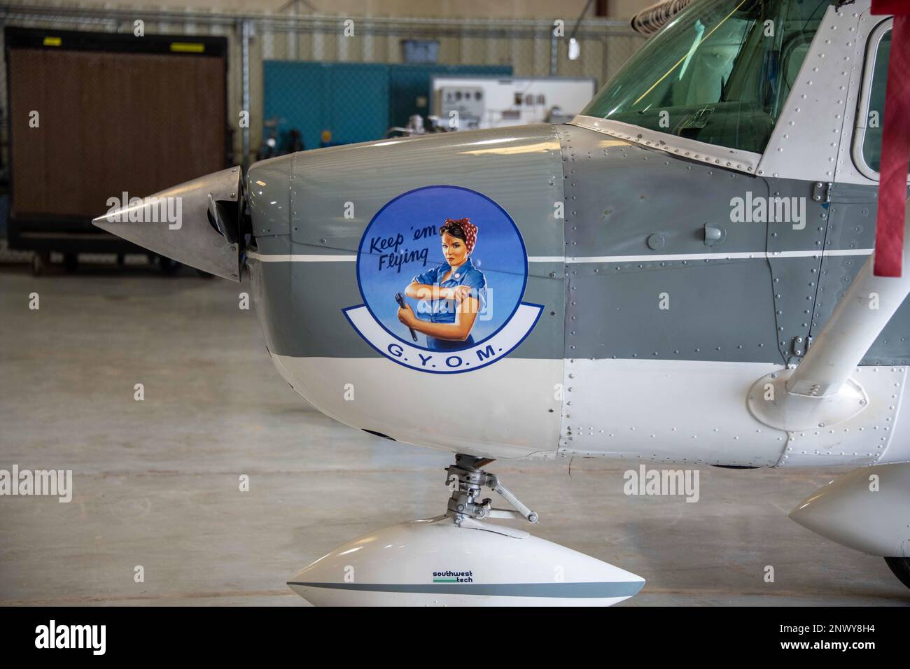 Das Logo „Grow Your Own Mechanic“ (GYOM), inspiriert von der Werbung „Rosie the Riveter“ aus den 40er Jahren, die am 11. Januar in einem Flugzeug im Hangar 33 in Altus, Oklahoma, zu sehen ist; 2023.GYOM ist ein gemäß Federal Aviation Part 147 zertifiziertes Programm, das mehr als 170 Mitarbeitern der 97. Maintenance Group am Luftwaffenstützpunkt Altus Beschäftigungsmöglichkeiten eröffnet hat. Stockfoto