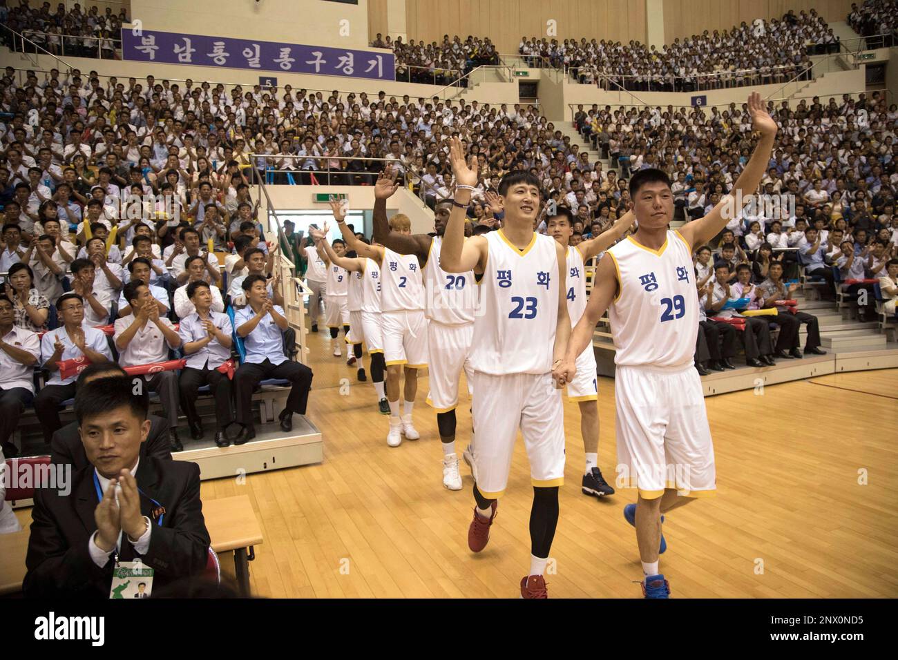 South and North Korean players of Team Peace wave as they arrive to play in their friendly basketball game at Ryugyong Jong Ju Yong Gymnasium in Pyongyang, North Korea, Wednesday, July 4, 2018. The rival Koreas on Wednesday began two days of friendly basketball games in Pyongyang in their latest goodwill gesture amid a diplomatic push to resolve the nuclear standoff with North Korea. Their uniforms read: "Peace." (Korea Pool via AP) Stockfoto