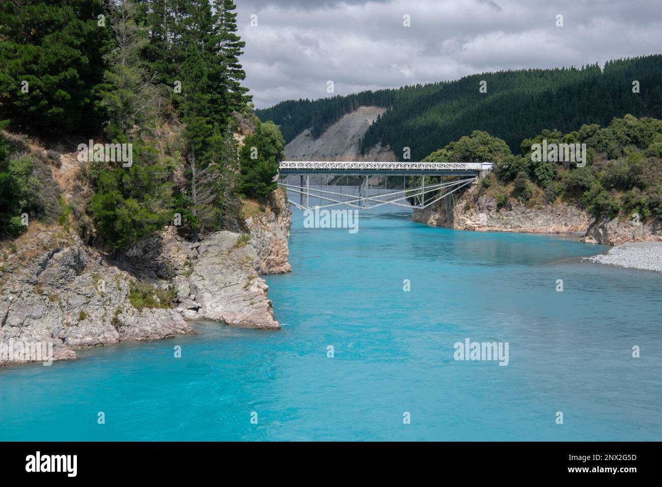 Die Rakaia River Gorge und die umliegende Landschaft, eine historische Brücke führt über das blaue Wasser, bestehend aus Gletscherschmelzwasser in Neuseeland. Stockfoto