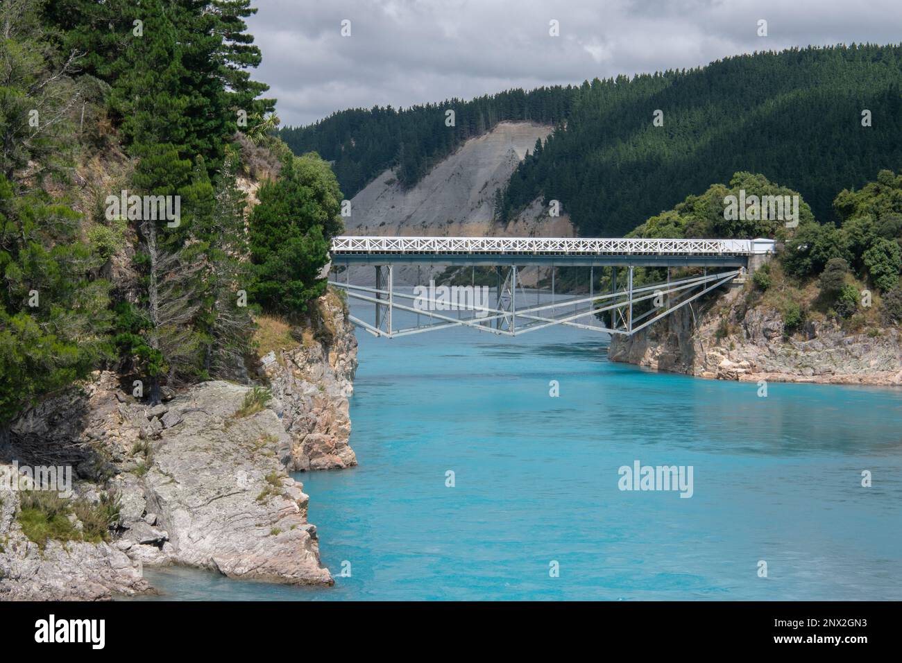 Die Rakaia River Gorge und die umliegende Landschaft, eine historische Brücke führt über das blaue Wasser, bestehend aus Gletscherschmelzwasser in Neuseeland. Stockfoto