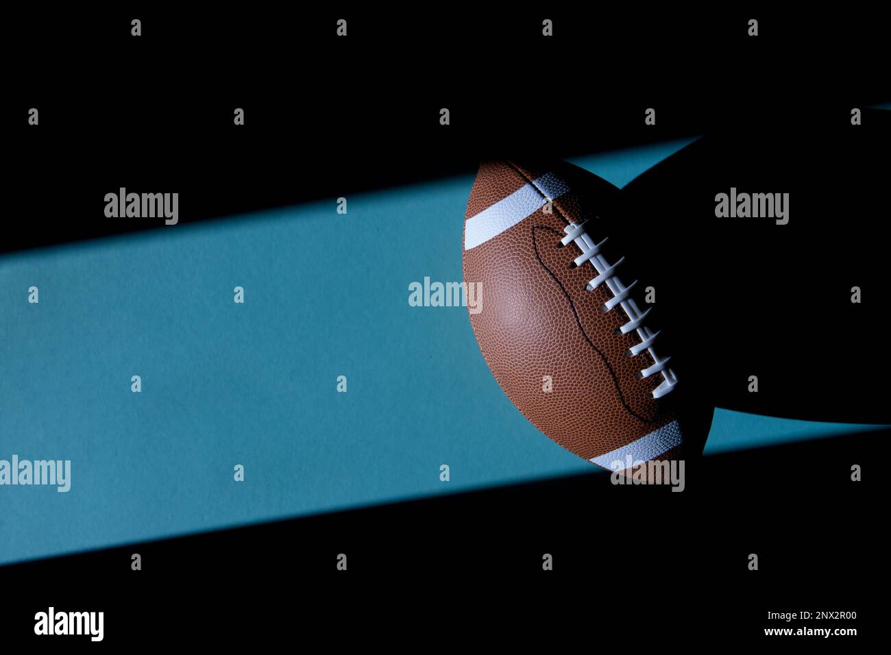 American Football Lederball auf blauem Hintergrund. Draufsicht. Spielausrüstung horizontales Sportposter, Grußkarten, Kopfzeilen, Website und App Stockfoto