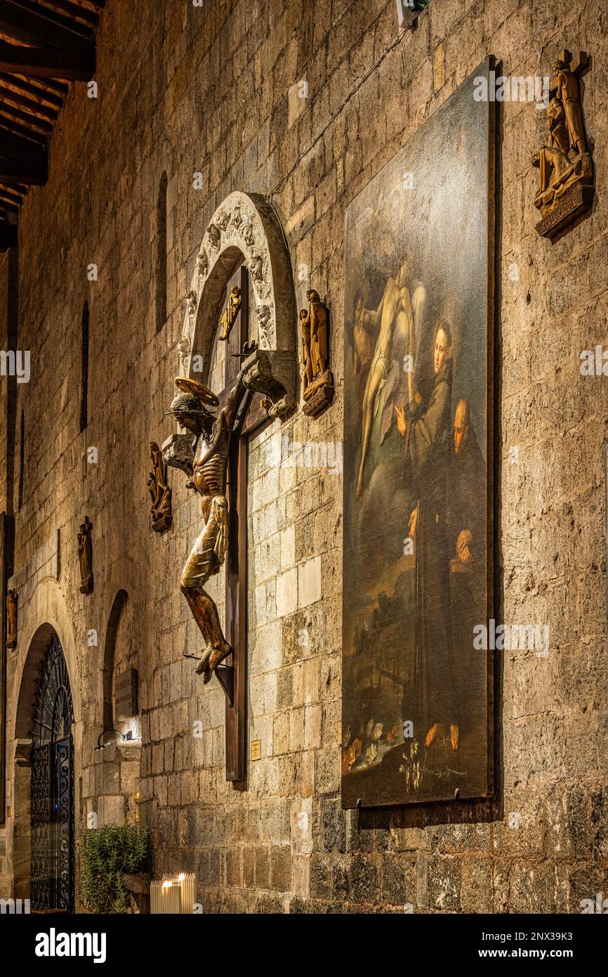 Ein großes hölzernes Kruzifix der umbrisch-sienesischen Schule, das von einem Majolica-Bogen mit Seraphim aus dem Buglioni-Workshop überragt wird. Bolsena, Latium Stockfoto