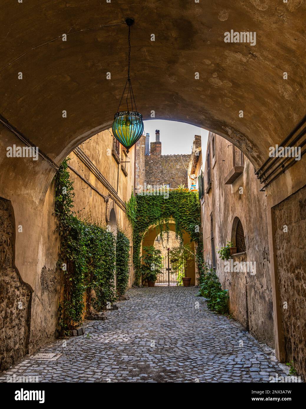 Malerische mittelalterliche Gasse mit Bögen und überdachten Wegen in der Altstadt von Tuscania. Toskanien, Provinz Viterbo, Latium, Italien, Europa Stockfoto