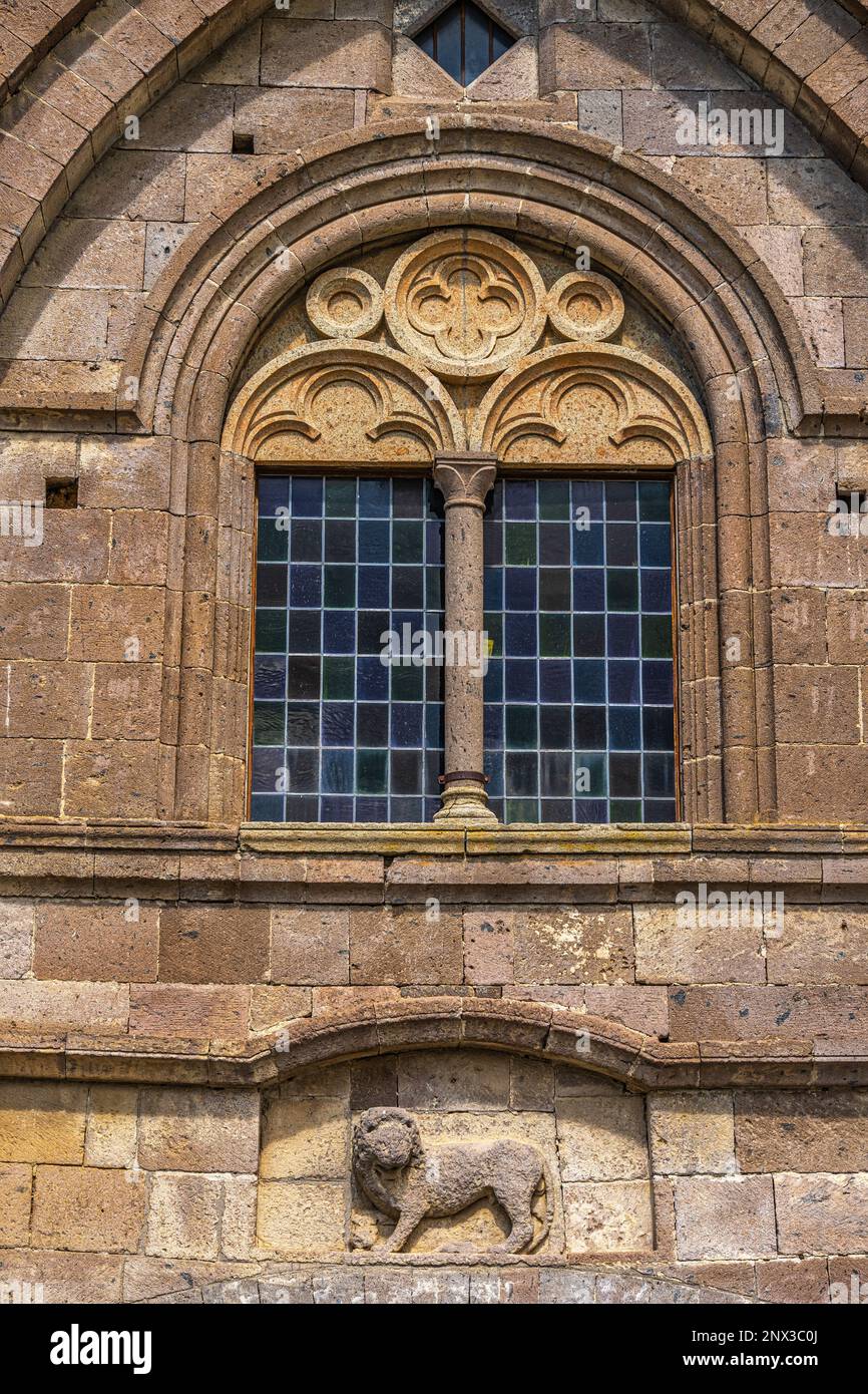 Detail der Fassade mit einem mehrfarbigen Fenster und einem Löwen in Relief der ehemaligen Kirche San Leonardo. Toskanien, Provinz Viterbo, Latium, Italien Stockfoto