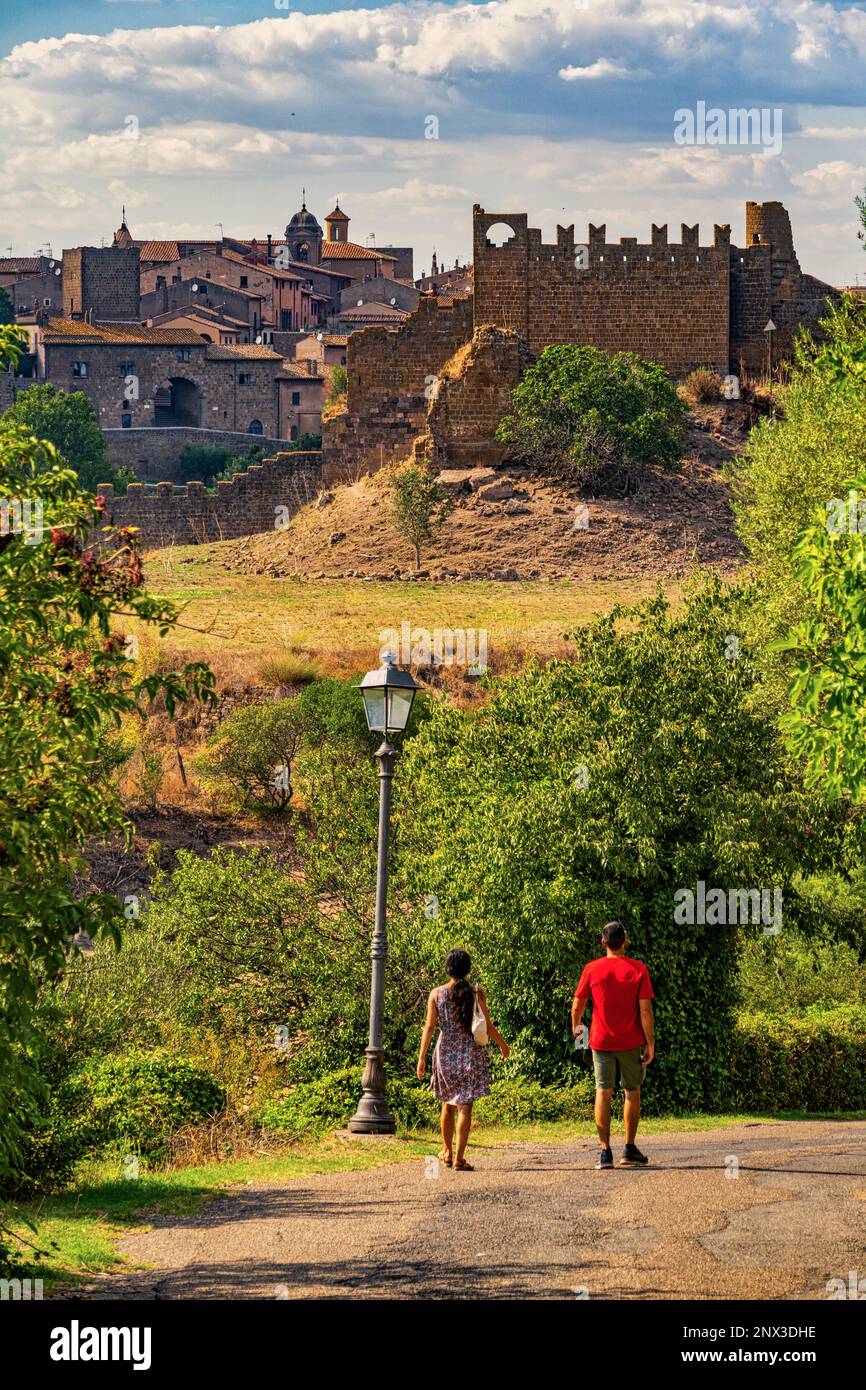 Touristen besuchen die antike Stadt Toskanien, im Hintergrund die Ruinen der Burg Rivellino. Toskanien, Provinz Viterbo, Latium, Italien, Europa Stockfoto