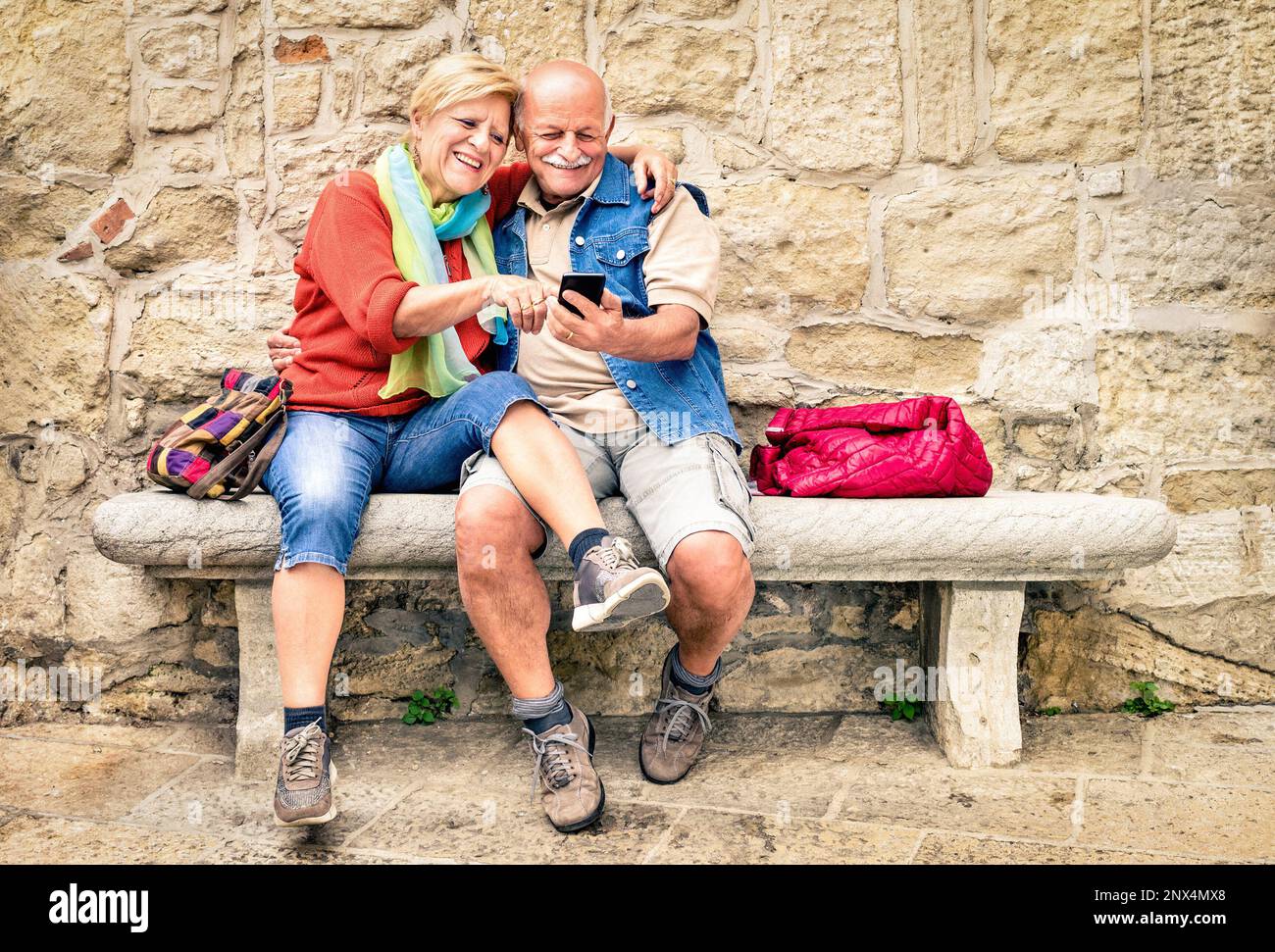 Glückliches Seniorenpaar, das mit dem Smartphone Spaß hat - Konzept aktiver verspielter Senioren im Ruhestand - Lifestyle-Konzept für Reisen Stockfoto Glückliches Seniorenpaar, das mit dem Smartphone Spaß hat - Konzept aktiver verspielter Senioren im Ruhestand - Lifestyle-Konzept für Reisen Stockfoto