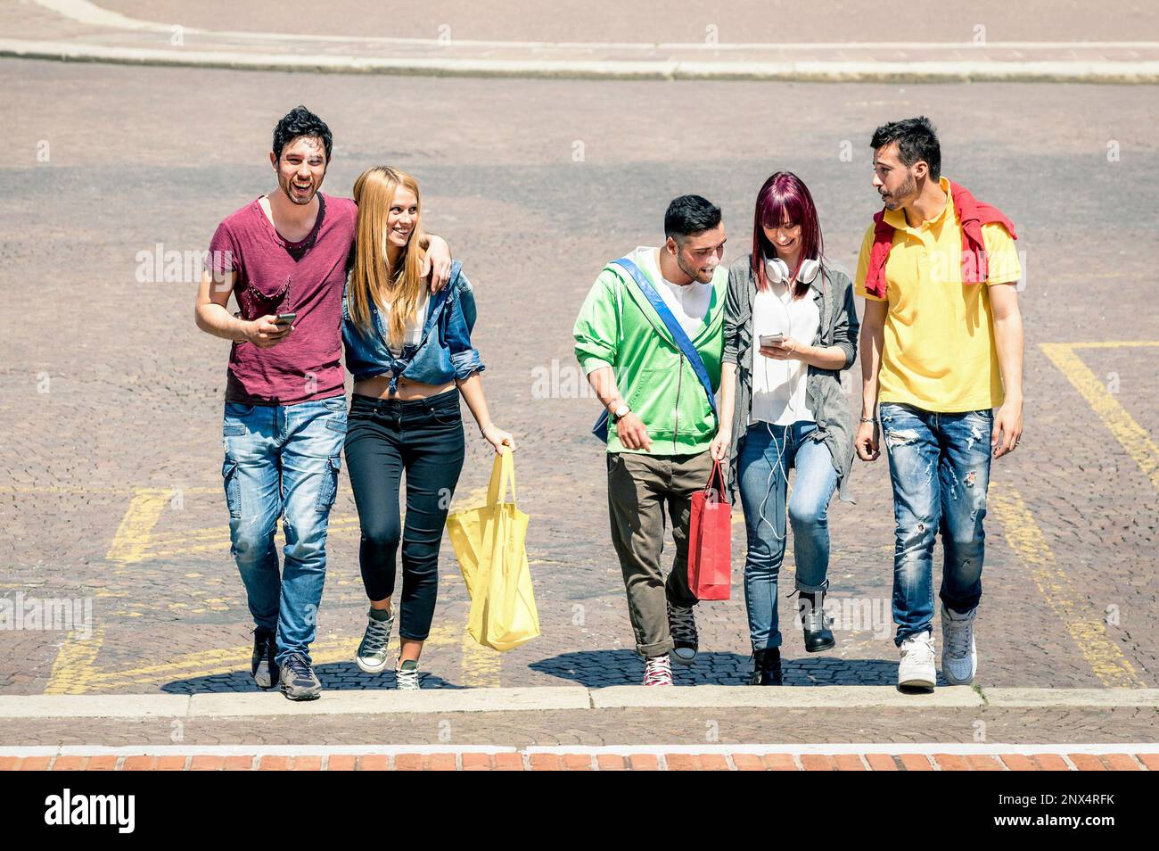 Glückliche beste Freunde, die im Stadtzentrum spazieren gehen und sich unterhalten - Touristen und Mädchen, die Spaß auf den Straßen der Stadt haben - Studenten der Universität im Sommerurlaub Stockfoto