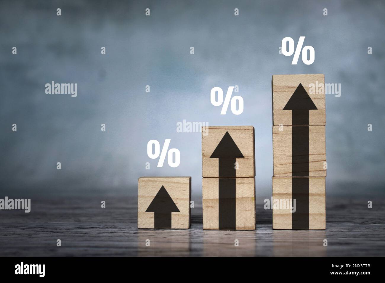 Holzblöcke mit Aufwärtspfeilen und Prozentzeichen. Zinsfinanzierung und Hypothekenzinskonzept. Stockfoto