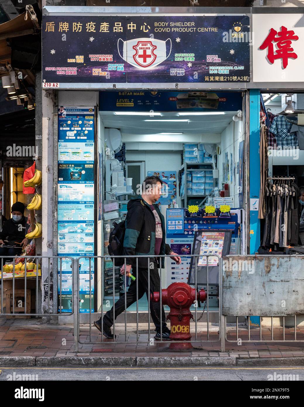 Hongkong, Hongkong. 01. März 2023. Ein maskenloser Mann schlendert an einem Spezialitätengeschäft in Shau Kei Wan, Hongkong vorbei. Mit schätzungsweise 300 Fachmaskenläden in ganz Hongkong, wird die plötzliche Entfernung des Maskenmandats am 1. März 2023 durch die Regierung voraussichtlich Tausende Quadratmeter Verkaufsfläche freisetzen. Das verheißt nichts Gutes für die Wirtschaft Hongkongs, da die Anzahl der Einzelhandelsleasingverträge in den letzten Jahren zurückgegangen ist, obwohl die Rückkehr von Touristen nach Hongkong neue wirtschaftliche Chancen schaffen könnte. Kredit: SOPA Images Limited/Alamy Live News Stockfoto