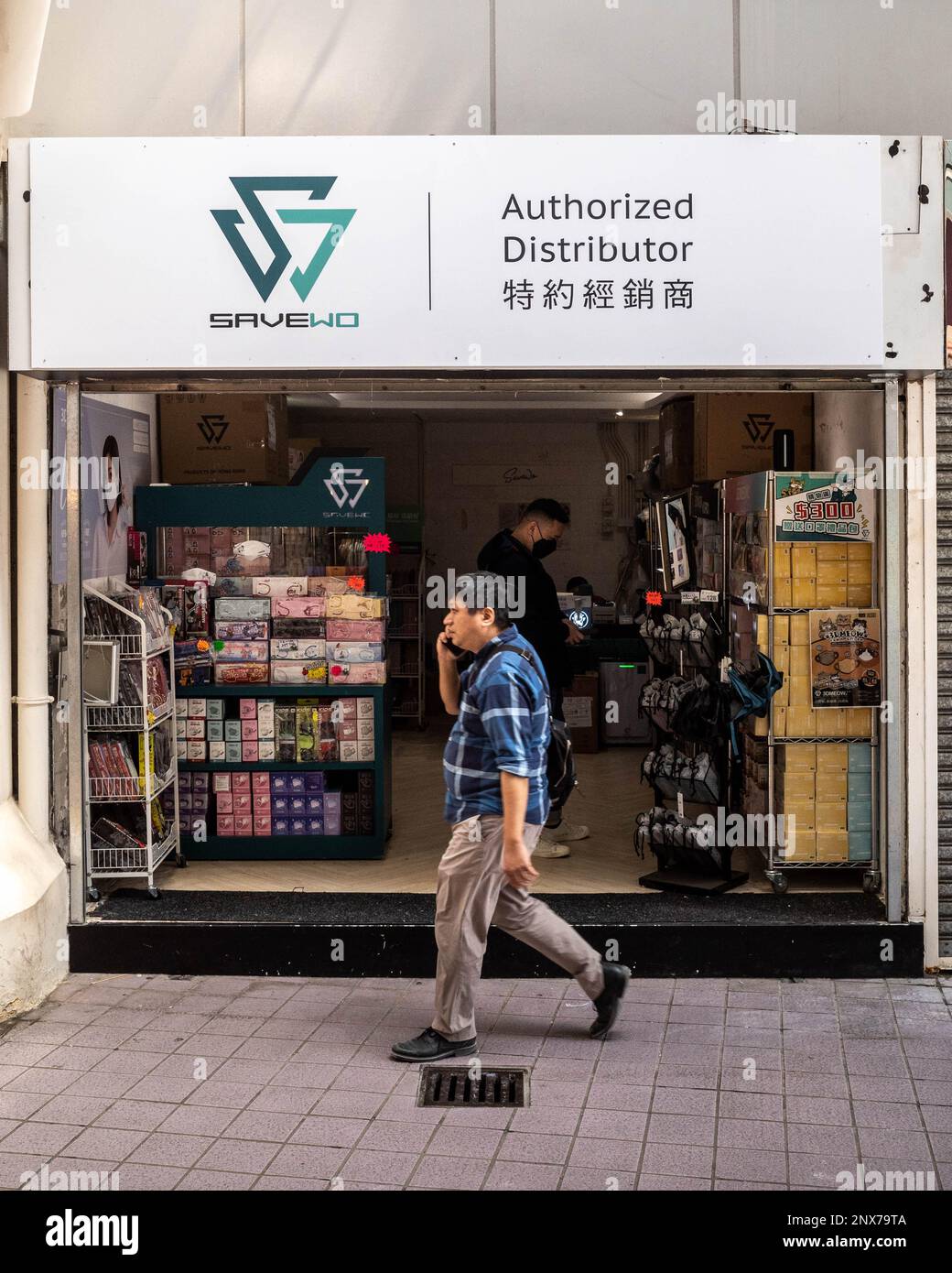 Hongkong, Hongkong. 01. März 2023. Ein masklenloser Mann schlendert an einem Spezialitätengeschäft in Causeway Bay, Hongkong vorbei. Mit schätzungsweise 300 Fachmaskenläden in ganz Hongkong, wird die plötzliche Entfernung des Maskenmandats am 1. März 2023 durch die Regierung voraussichtlich Tausende Quadratmeter Verkaufsfläche freisetzen. Das verheißt nichts Gutes für die Wirtschaft Hongkongs, da die Anzahl der Einzelhandelsleasingverträge in den letzten Jahren zurückgegangen ist, obwohl die Rückkehr von Touristen nach Hongkong neue wirtschaftliche Chancen schaffen könnte. Kredit: SOPA Images Limited/Alamy Live News Stockfoto