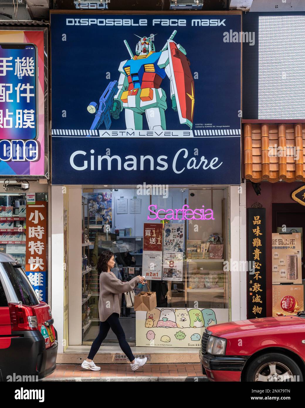 Hongkong, Hongkong. 01. März 2023. Eine maskenlose Frau läuft vor einem Spezialmaskenladen in Causeway Bay, Hongkong. Mit schätzungsweise 300 Fachmaskenläden in ganz Hongkong, wird die plötzliche Entfernung des Maskenmandats am 1. März 2023 durch die Regierung voraussichtlich Tausende Quadratmeter Verkaufsfläche freisetzen. Das verheißt nichts Gutes für die Wirtschaft Hongkongs, da die Anzahl der Einzelhandelsleasingverträge in den letzten Jahren zurückgegangen ist, obwohl die Rückkehr von Touristen nach Hongkong neue wirtschaftliche Chancen schaffen könnte. Kredit: SOPA Images Limited/Alamy Live News Stockfoto