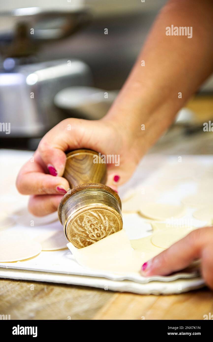 Die Herstellung der traditionellen „Corzetti“, einer typischen Pasta aus der italienischen Region Ligurien, die jede Pasta entsprechend der Tradition stempelt. Stockfoto