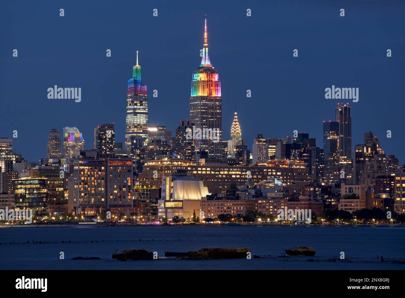 In New York City. Das Empire State Building und die Wolkenkratzer von Venderbilt werden für die LGBTQ+ Gay Pride Week in Regenbogenfarben beleuchtet. Midtown, Manhattan Stockfoto