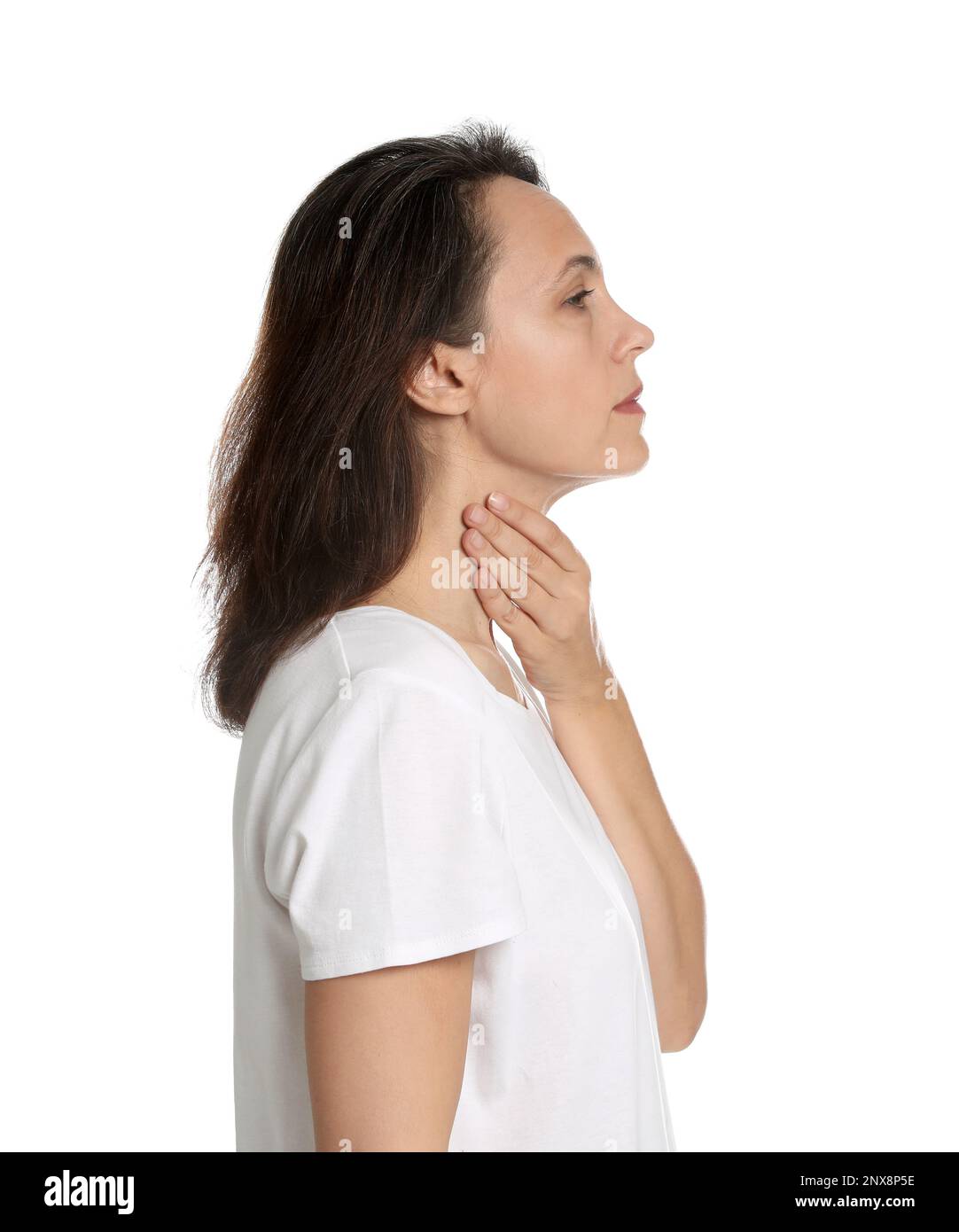 Reife Frau, die Schilddrüsen-Selbstuntersuchung auf weißem Hintergrund durchführt Stockfoto