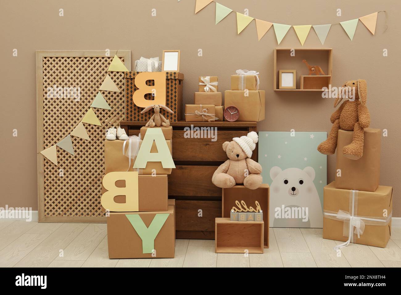 Geschenkschachteln und Spielzeuge im Zimmer, die für Babyduschpartys dekoriert sind Stockfoto