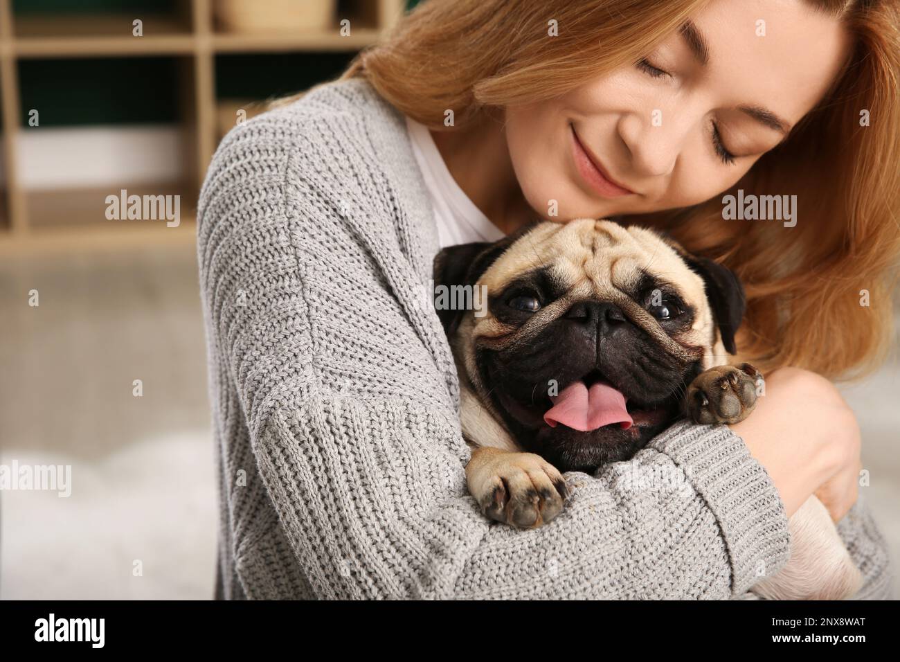 Eine Frau mit süßem Hund zu Hause. Adoption von Tieren Stockfoto