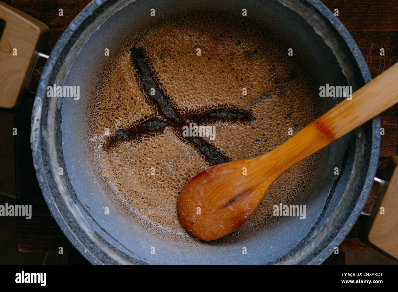 Leere verbrannte Töpfe mit X auf einem Holztisch, verbrannte Milch, unsauberer, verfleckter Topf oder beim Kochen verbrannte Pfanne Stockfoto
