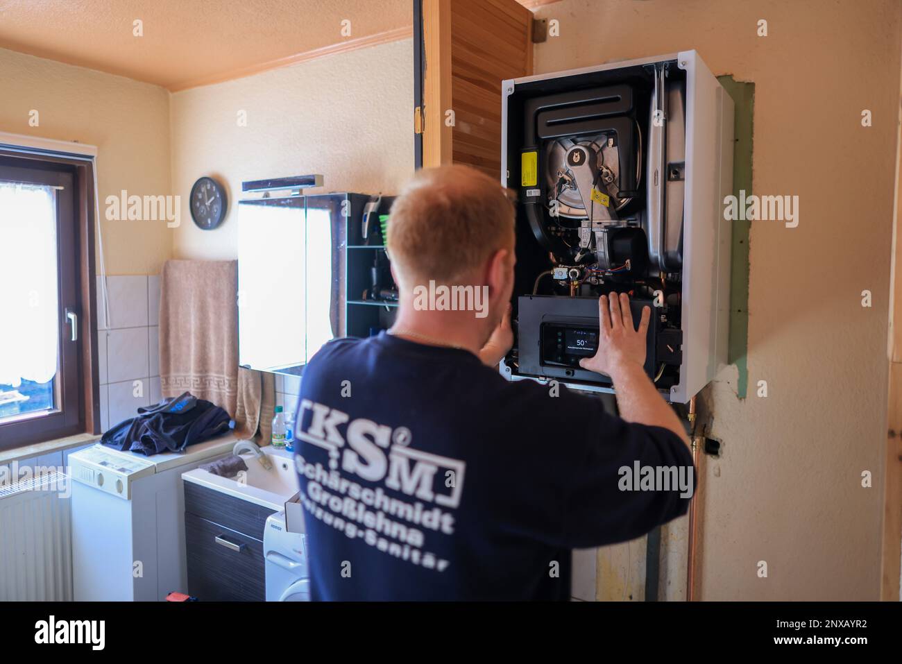 01. März 2023, Sachsen, Markranstädt: Ein Mitarbeiter eines Installations- und Heizungsunternehmens installiert einen modernen Gaskondensierkessel in einem Einfamilienhaus. Die Pläne der Ampelkoalition für die Umstellung der Heizung auf erneuerbare Energien nehmen Gestalt an. Ab 2024 sollen keine neuen Erdgas- und Erdölheizanlagen mehr installiert werden. Sie würden durch Heizsysteme ersetzt, die zu mindestens 65 Prozent mit erneuerbarer Energie betrieben werden. Derzeit heizt jeder zweite Haushalt in Deutschland mit Erdgas. Die FDP ist äußerst kritisch - und die Fachleute warnen davor, sich für Technologien zu engagieren. Stockfoto